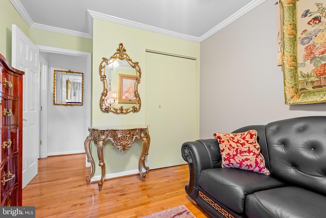 living area with light hardwood / wood-style flooring and crown molding