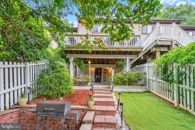 rear view of property with a wooden deck and a lawn