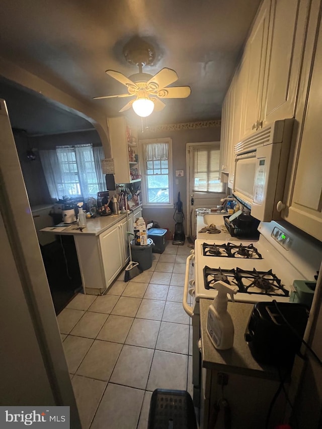 kitchen featuring white appliances, ceiling fan, and light tile patterned floors