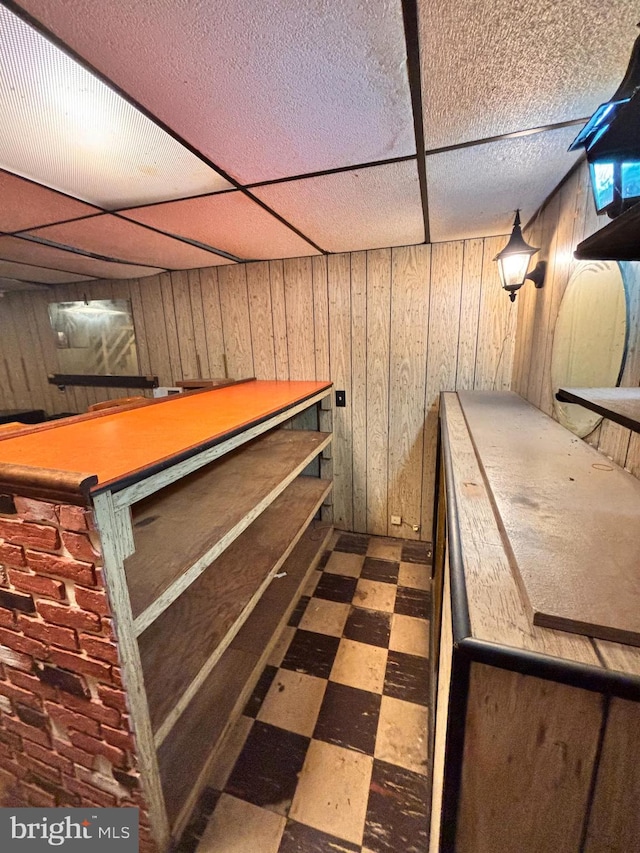 bar with a drop ceiling and wood walls