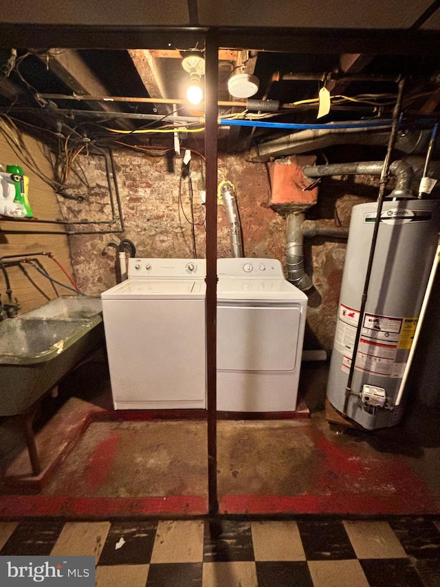 basement featuring separate washer and dryer, gas water heater, and sink