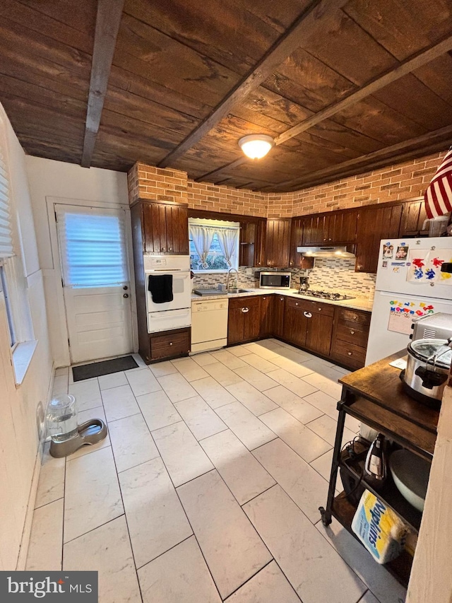 kitchen with light tile patterned flooring, wood ceiling, sink, tasteful backsplash, and stainless steel appliances