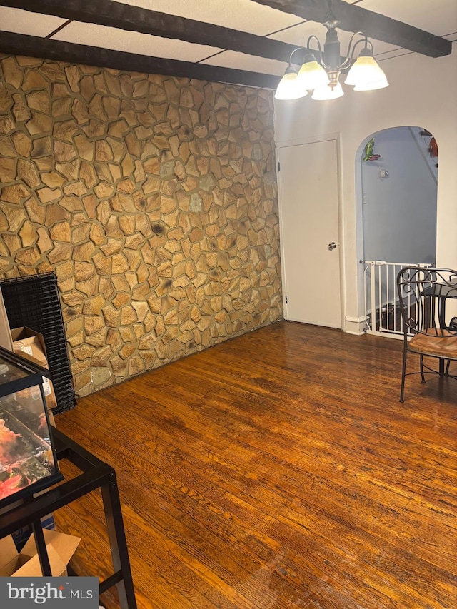 interior space with beamed ceiling and dark hardwood / wood-style floors