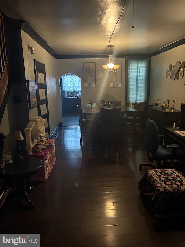 dining room with ornamental molding, dark hardwood / wood-style floors, and an inviting chandelier