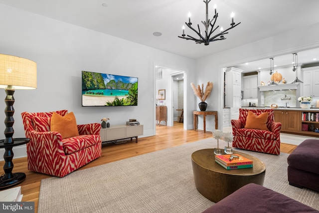 living room with light wood-type flooring and an inviting chandelier