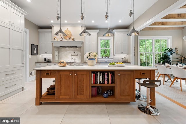 kitchen featuring a large island, white cabinets, and decorative light fixtures