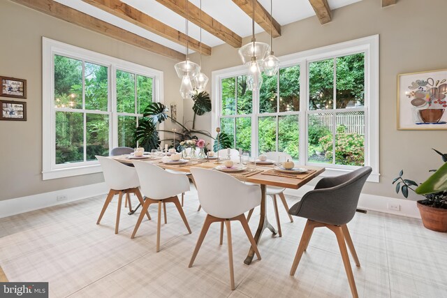 dining space featuring beam ceiling and a wealth of natural light