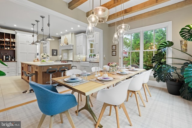 dining room featuring beamed ceiling and light tile patterned floors