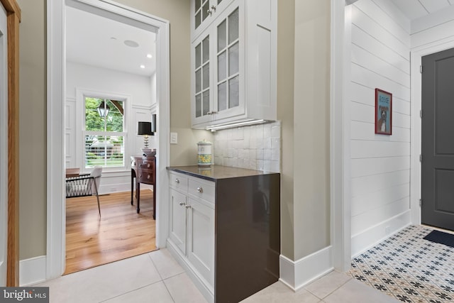 kitchen with white cabinets, light tile patterned flooring, and tasteful backsplash