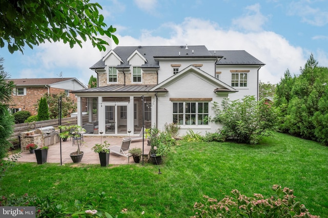 back of property featuring a lawn, a patio, and a sunroom