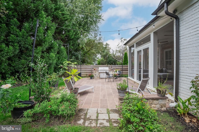 view of patio with a sunroom and a grill