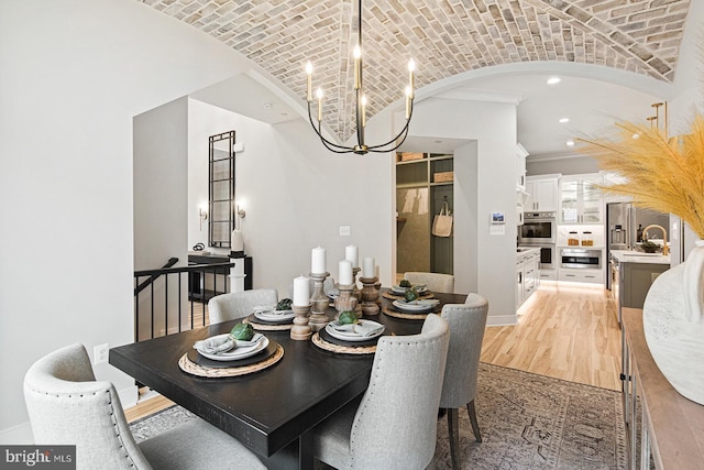 dining space featuring brick ceiling, lofted ceiling, recessed lighting, light wood finished floors, and a notable chandelier