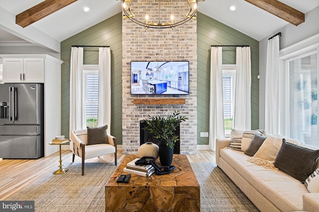 living room with wooden walls, a notable chandelier, vaulted ceiling with beams, and light wood finished floors