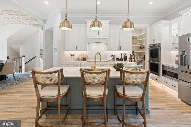 kitchen with recessed lighting, a breakfast bar area, white cabinets, and stainless steel appliances