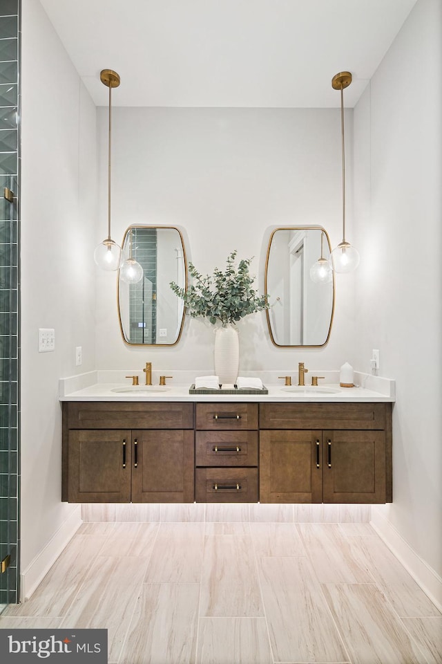 full bathroom with double vanity, baseboards, and a sink