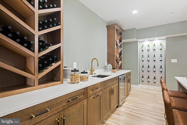wine area with a sink and light wood finished floors