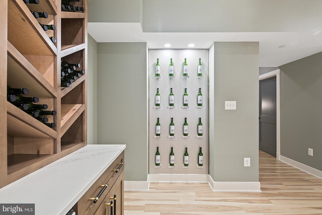wine room with baseboards, recessed lighting, and light wood-style floors