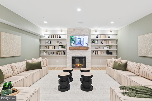 living area featuring recessed lighting, a tiled fireplace, and wood finished floors