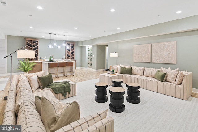 living area with recessed lighting, baseboards, visible vents, and light wood-type flooring