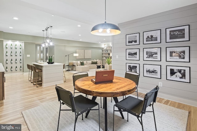dining space featuring light wood-type flooring, recessed lighting, and baseboards