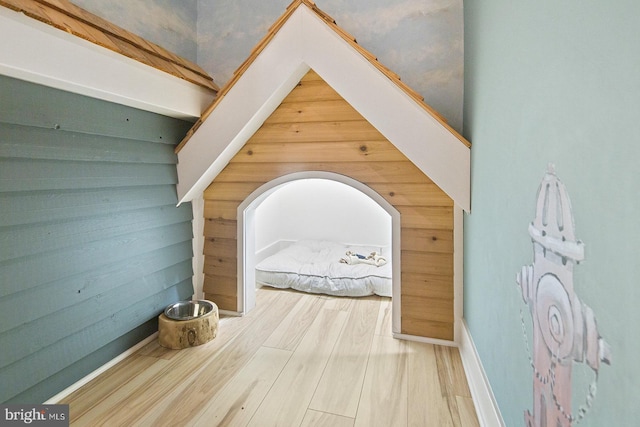 additional living space featuring wood walls and wood finished floors