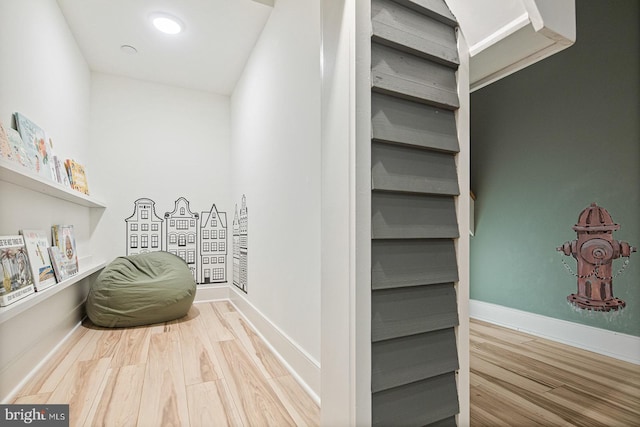 hall with baseboards and wood finished floors