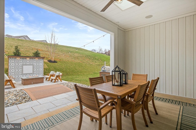 view of patio / terrace featuring outdoor dining area, ceiling fan, and an outdoor fire pit