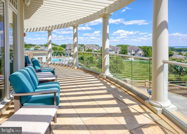 view of patio / terrace featuring a pergola, a residential view, and a balcony