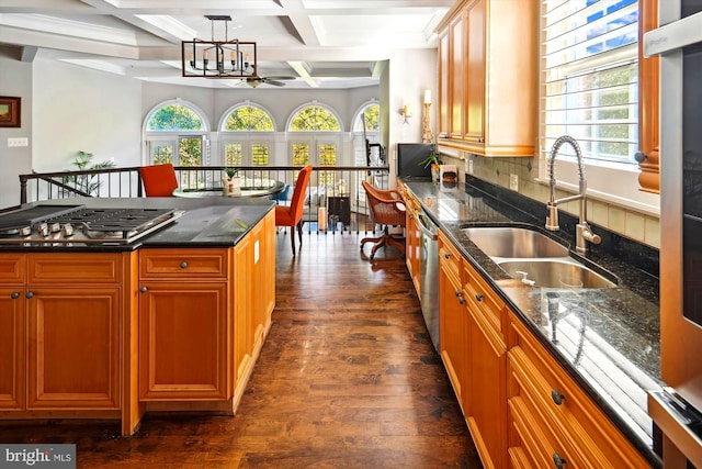 kitchen with pendant lighting, coffered ceiling, dark wood-type flooring, sink, and backsplash