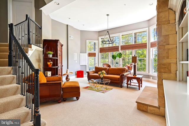 carpeted living room with a chandelier