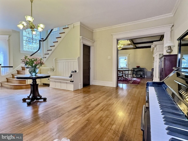 entryway featuring ornamental molding, hardwood / wood-style floors, a chandelier, and plenty of natural light