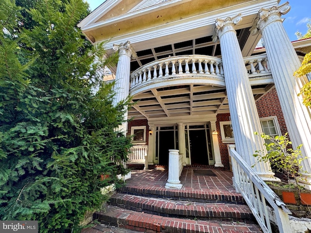 view of exterior entry with a balcony