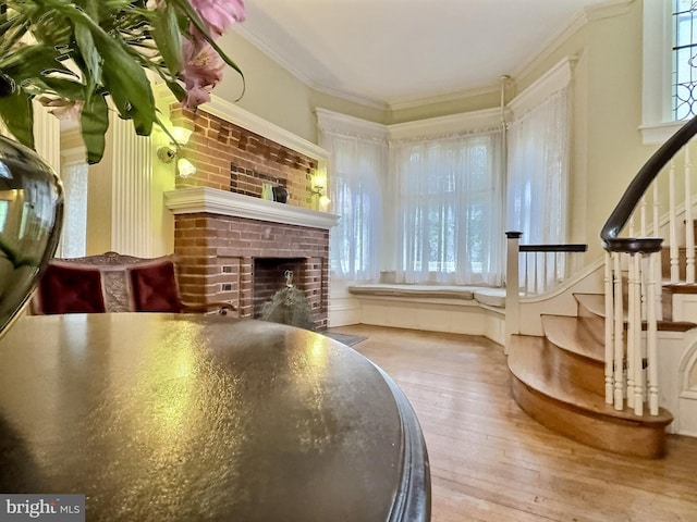 interior space featuring hardwood / wood-style flooring, a fireplace, and crown molding