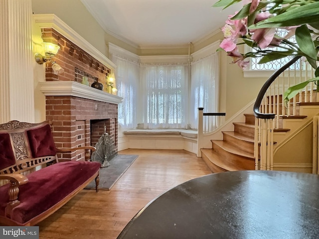 interior space featuring crown molding, hardwood / wood-style floors, and a brick fireplace