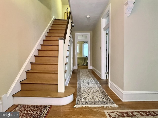 stairs featuring hardwood / wood-style floors