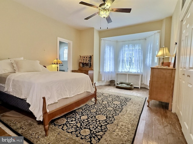 bedroom with hardwood / wood-style floors, ceiling fan, and a closet