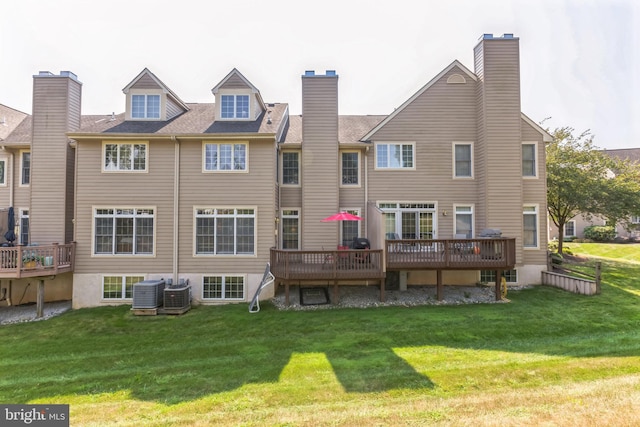 back of property with central AC unit, a deck, and a yard