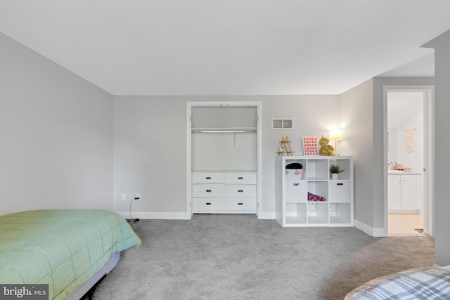 bedroom with connected bathroom and light carpet