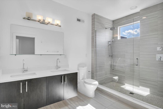 bathroom featuring tile patterned floors, vanity, a shower with door, and toilet