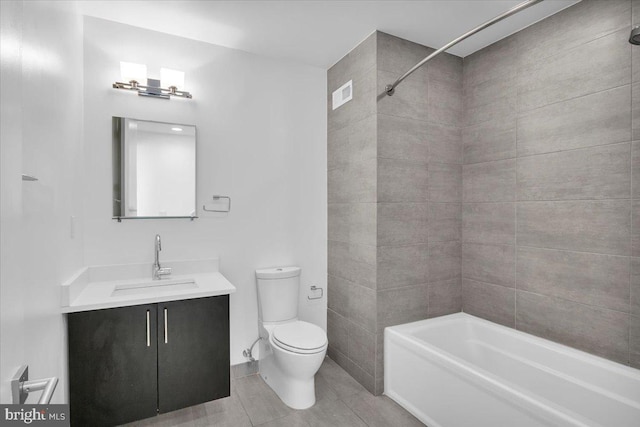 full bathroom featuring tiled shower / bath, tile patterned floors, vanity, and toilet