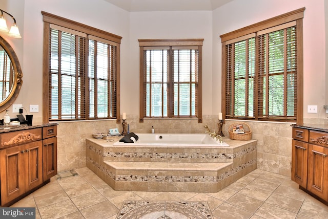 bathroom featuring vanity, tiled bath, tile patterned flooring, and tile walls