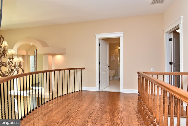 hall featuring hardwood / wood-style flooring and a chandelier