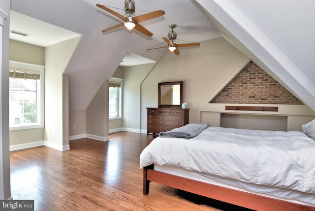 bedroom with ceiling fan, lofted ceiling, hardwood / wood-style floors, and multiple windows