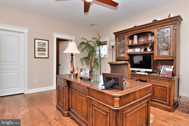 home office featuring baseboards, ceiling fan, visible vents, and light wood-type flooring