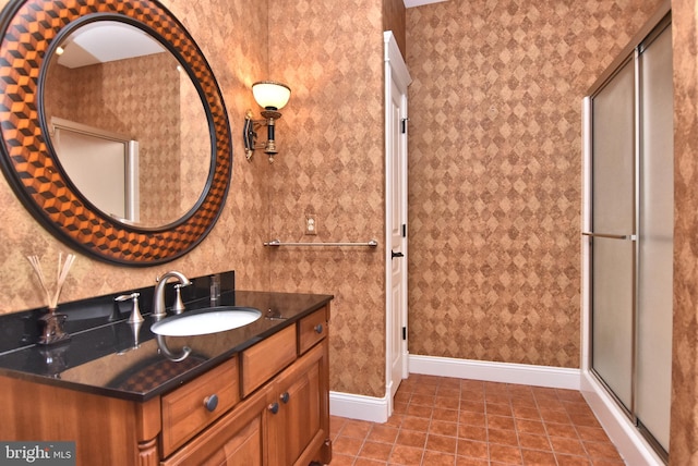 bathroom with tile patterned flooring, vanity, baseboards, and an enclosed shower