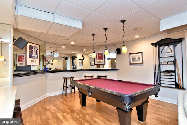 game room featuring pool table, bar area, hardwood / wood-style floors, and a paneled ceiling