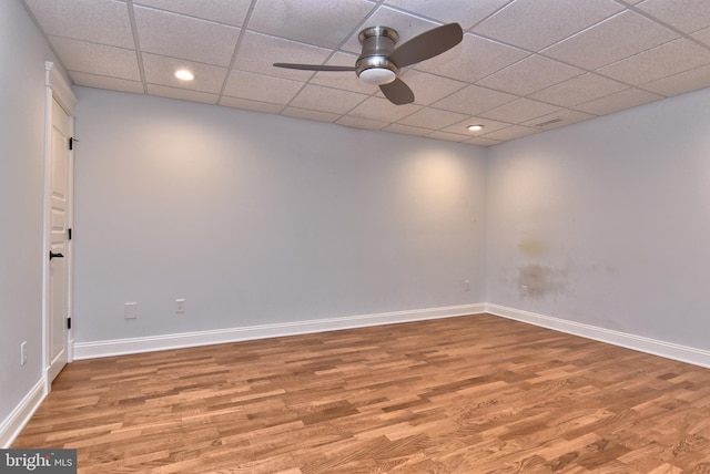 unfurnished room with ceiling fan, a drop ceiling, and wood-type flooring