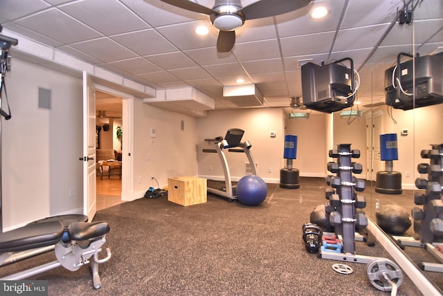 interior space with baseboards, visible vents, a ceiling fan, and a drop ceiling