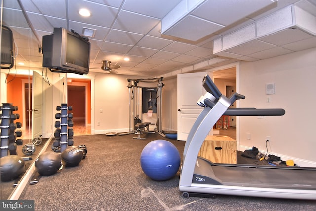 exercise room with a drop ceiling, visible vents, baseboards, and ceiling fan