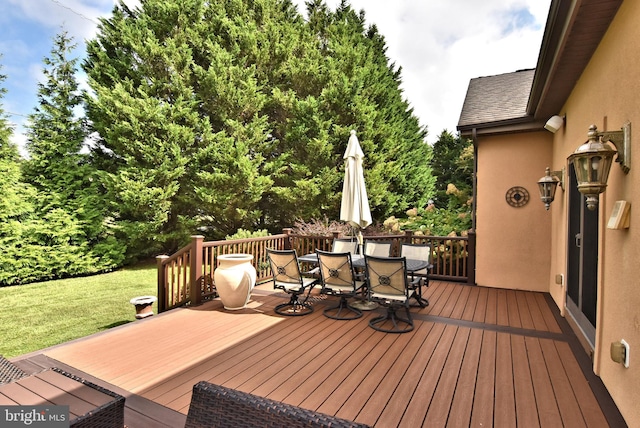 deck featuring a lawn and outdoor dining space